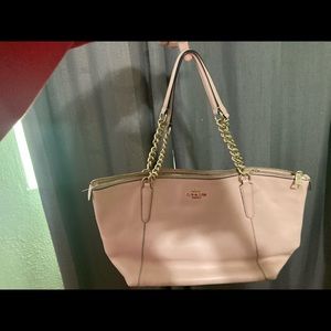 Medium sized, light pink coach purse.